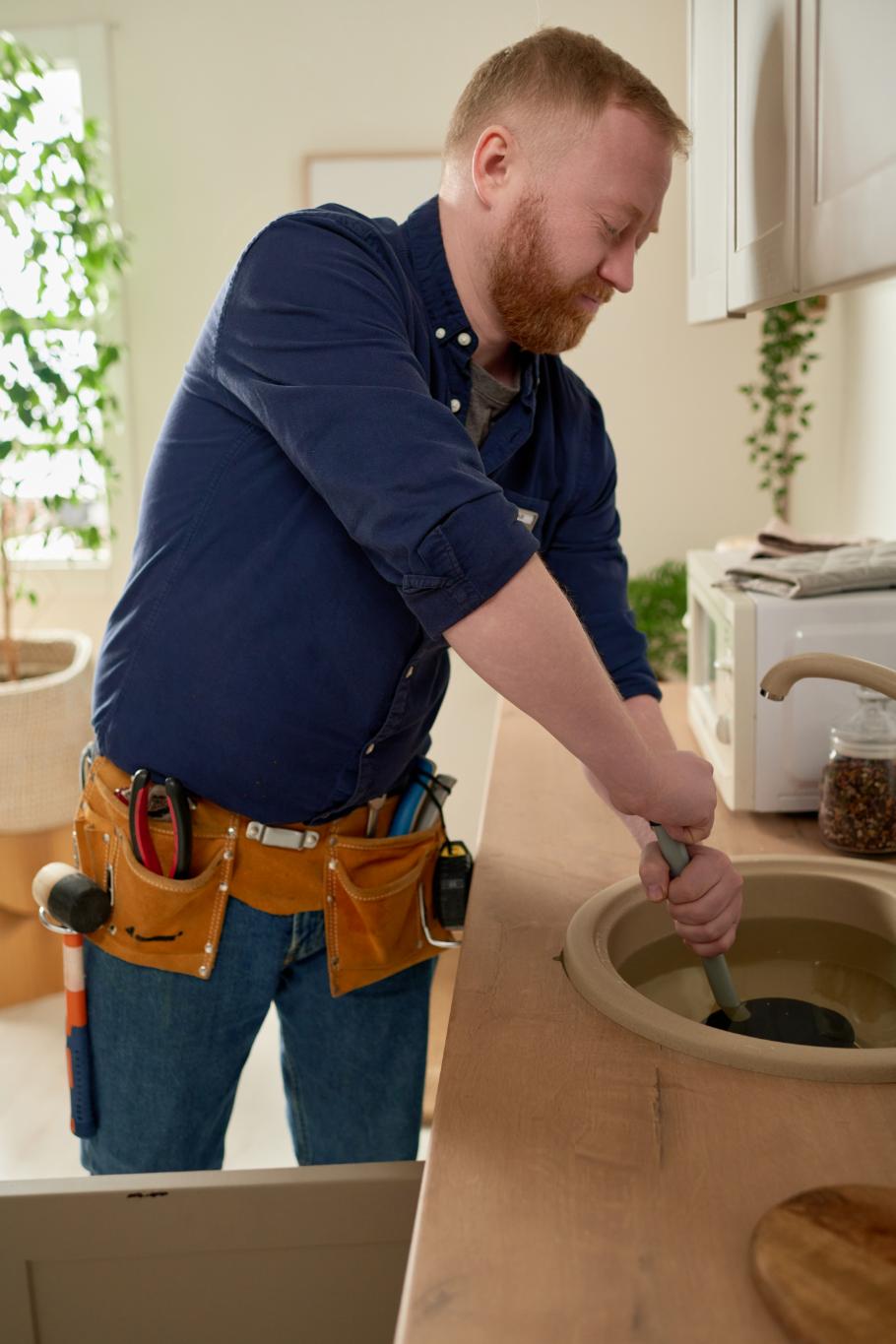 Plumber working on a clogged kitchen sink